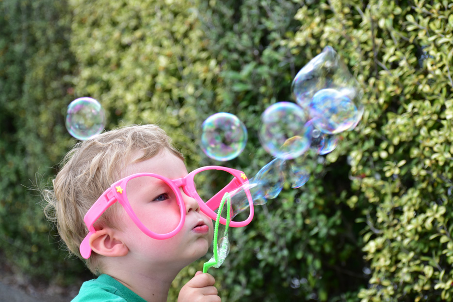 Photo of a little boy blowing bubbles, taken with the AF-P DX NIKKOR 70-300mm f/4.5-6.3G ED lens