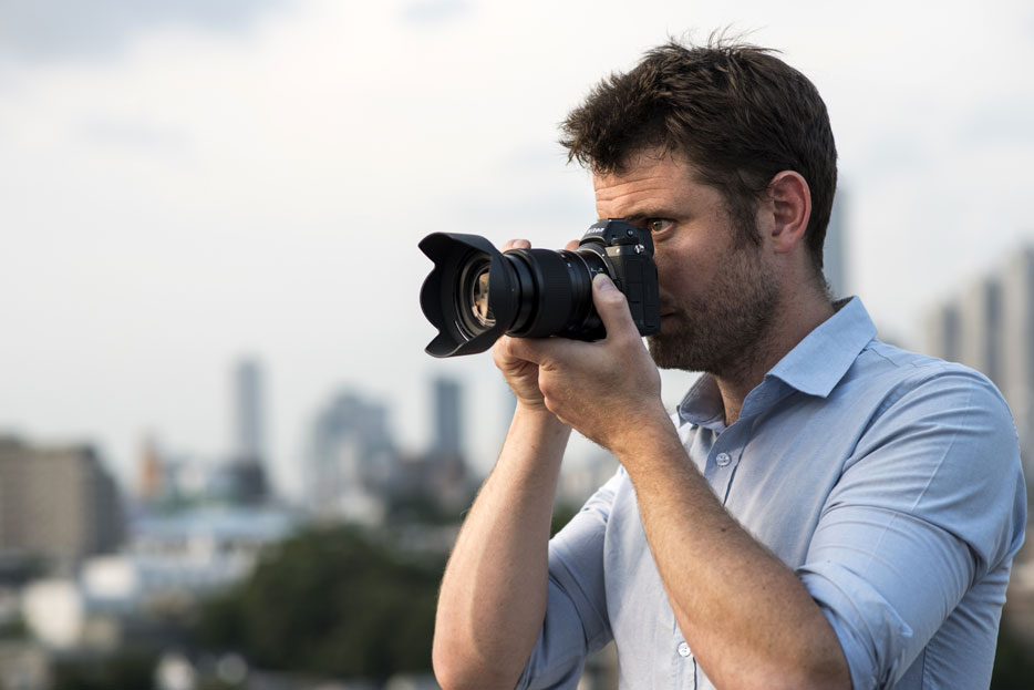 photo of a man holding the Z 7 and NIKKOR Z 24-70mm f/4 S lens